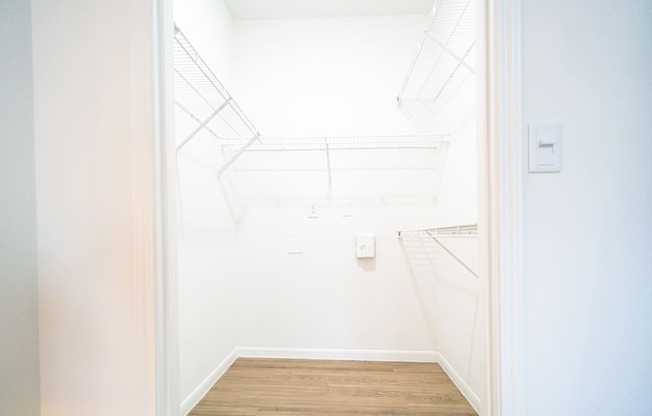 a white room with a wood floor and a white door
