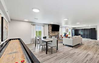 A room with a pool table in the foreground and a dining area in the background.