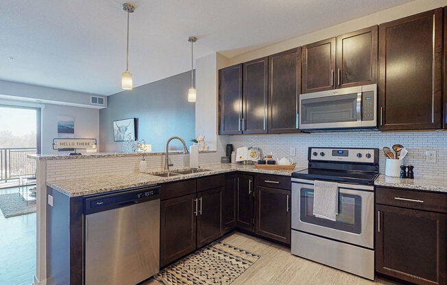 One bedroom apartment, kitchen stainless steel appliances, granite countertops, tile backsplash at The Axis, Plymouth, MN