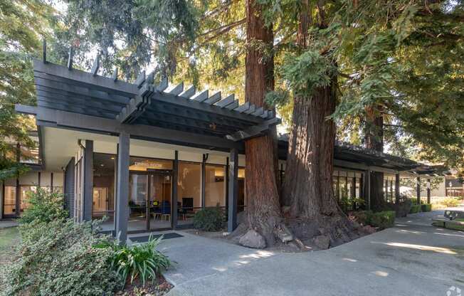 the exterior of a building with trees in front of it