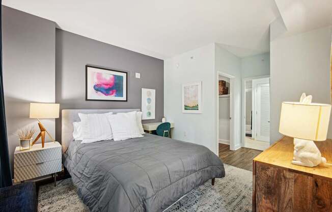 A bedroom with a large bed and a painting on the wall.