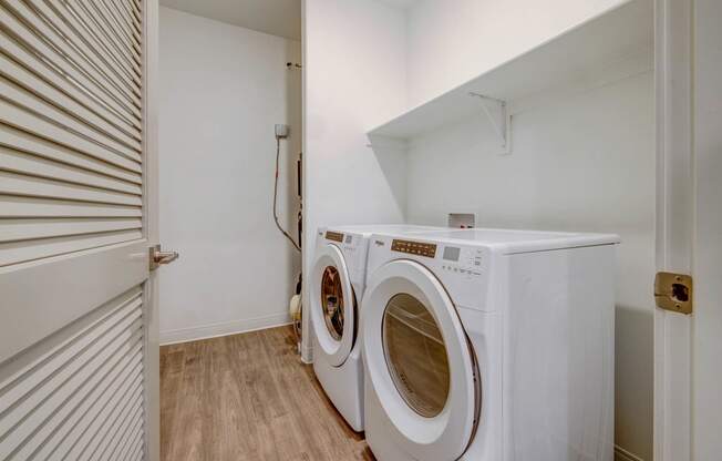 a washer and dryer in a laundry room with a white closet
