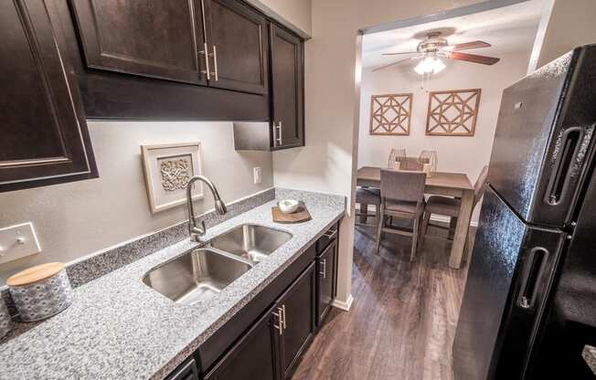 Renovated Kitchen with granite countertops and stainless-steel sink at Chelsea Village Apartments
