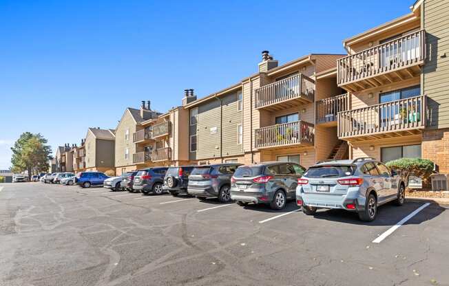 a row of cars parked in front of an apartment building