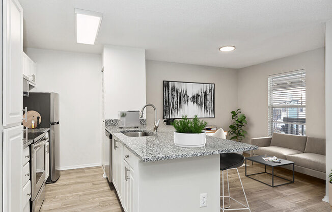 Model Kitchen with White Cabinets and Wood-Style Flooring at Seven Lakes at Carrollwood Apartments in Tampa, FL.