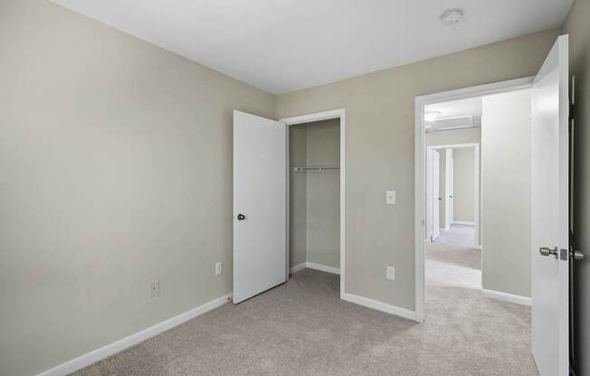 A room with a carpeted floor and a white door.