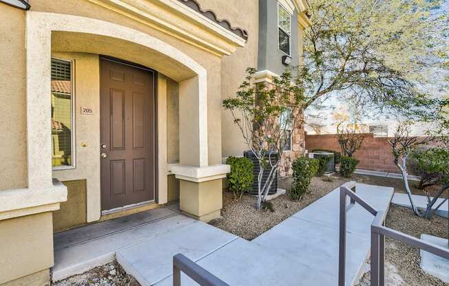 A house with a brown door and a small garden in front.