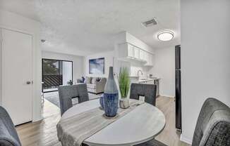 A modern dining room with a round table and grey chairs.