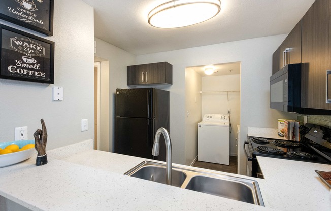 a kitchen with a sink and a counter and a refrigerator