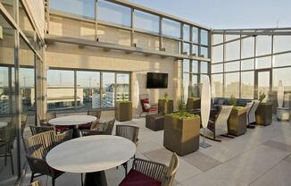 a lobby with tables and chairs and large windows