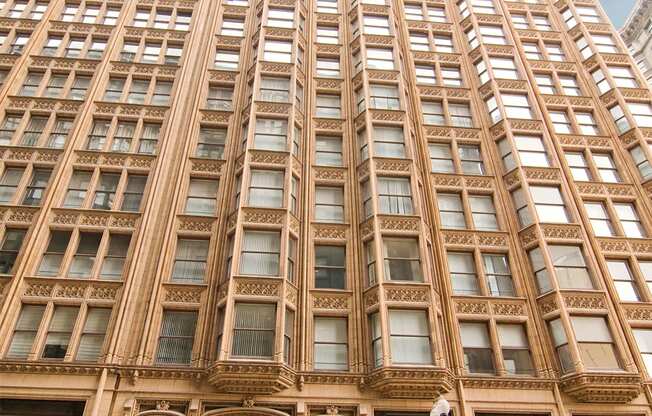 a tall building with many windows and a street in front of it