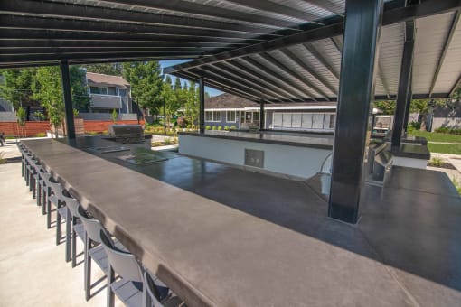 Resident outdoor kitchen with a long table and chairs