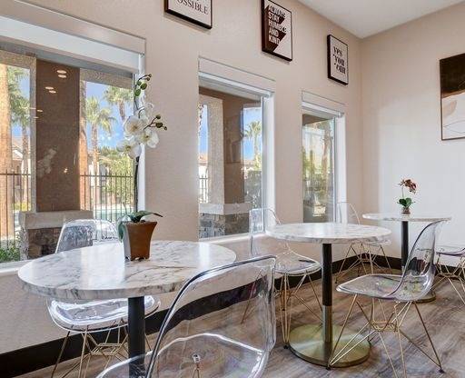 A dining room with a white table and chairs.