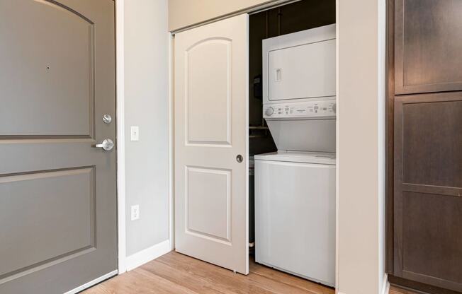 a door is open to a closet with a washer and dryer