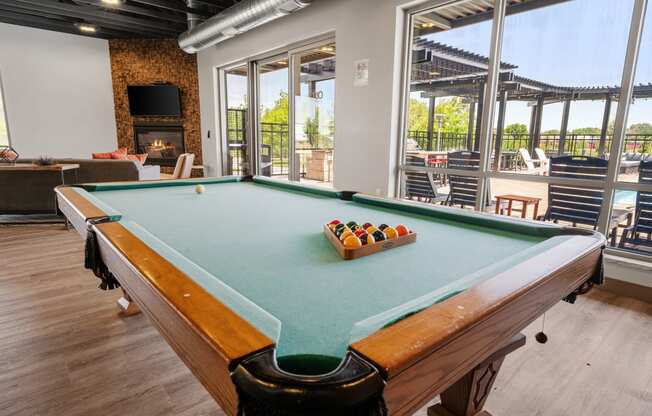 a pool table in the resident clubhouse at TRIO @ Southbridge apartments