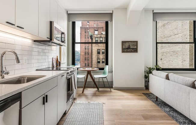 a kitchen with white cabinets and a sink and a window at The Commonwealth Building, Pittsburgh