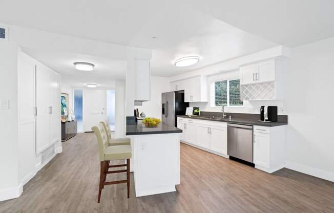 a kitchen with white cabinetry and a black counter top