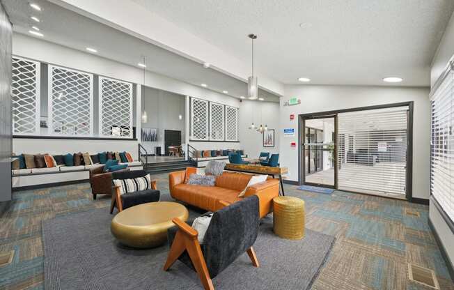 A modern office lounge with a variety of seating options and a patterned carpet.