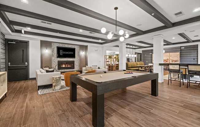 A billiard table is in the middle of a room with a fireplace