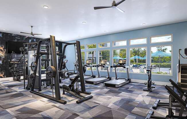 a gym with weights and cardio equipment in a building with windows