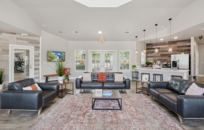 A living room with a large rug and a coffee table in the middle.