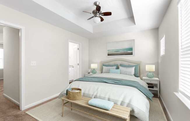 A bedroom with a bed, nightstands, and a ceiling fan.