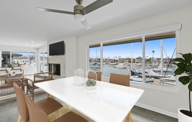 a living room with a white table and chairs and a view of a marina