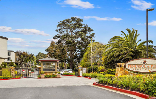 the entrance with a sign and palm trees