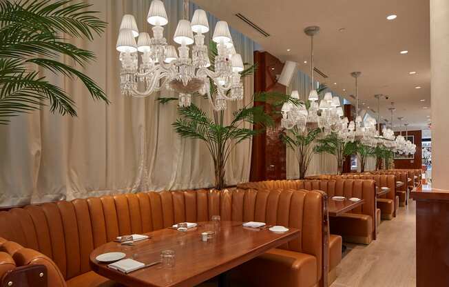 A restaurant with brown booths and a chandelier hanging from the ceiling.