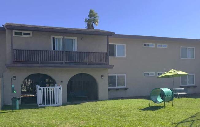 A building with a balcony and a palm tree on top.