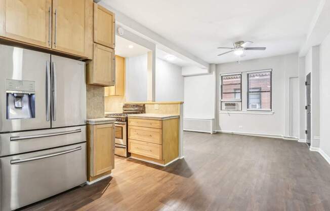 A kitchen with wooden cabinets and a stainless steel refrigerator.