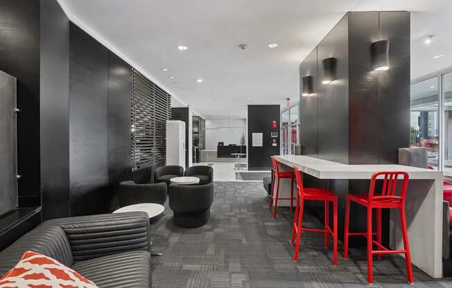A black and red themed cafe with a long table and chairs.