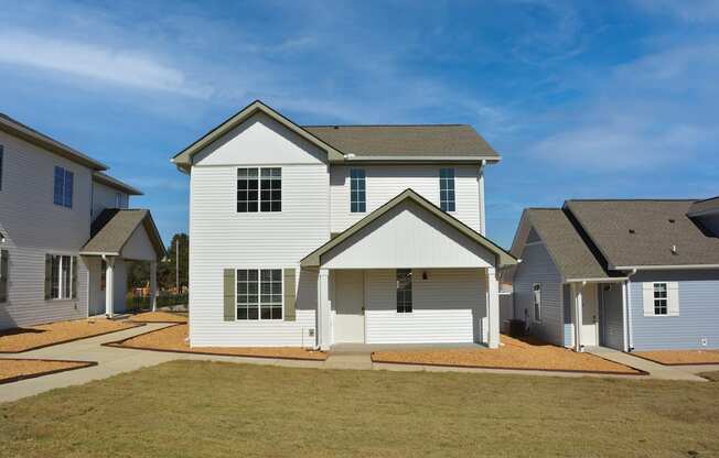 a white house with a blue sky and green grass at The Sanctuary at Indian Creek