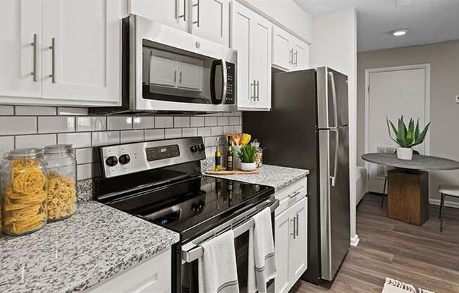 a kitchen with a stove top oven next to a refrigerator at Trails at Short Pump Apartments, Virginia,23233