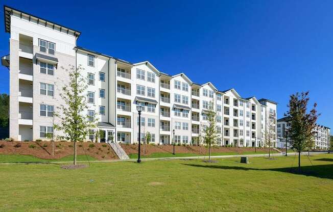 a large apartment building with green grass in front of it