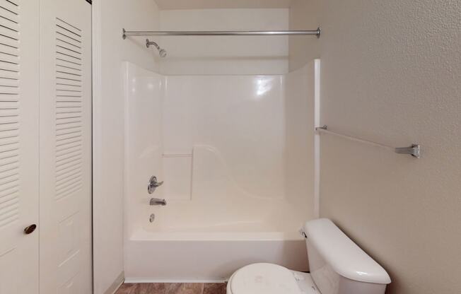a bathroom with a toilet and a tub and a shower