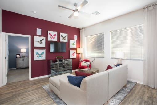 a living room with a red accent wall and a white couch