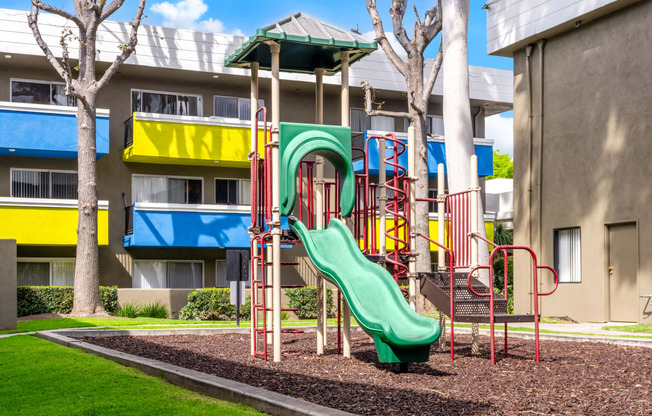a playground in front of a building with a slide