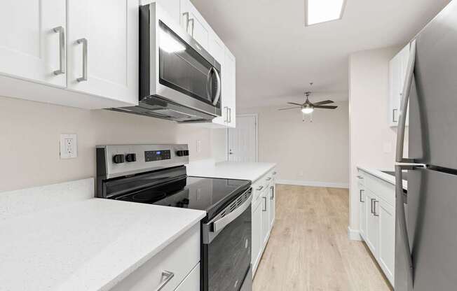 A kitchen with white cabinets and black appliances.