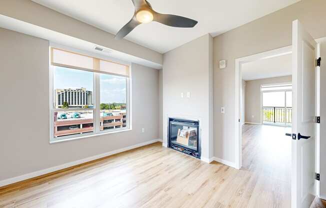 a living room with wood floors and a fireplace     and a window