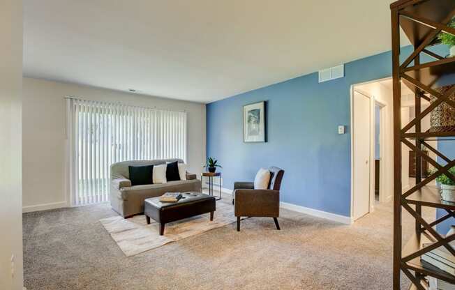 a living room with a blue wall and a couch - Maple Place Apartments