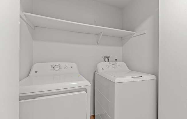 A small laundry room with a washer and dryer.