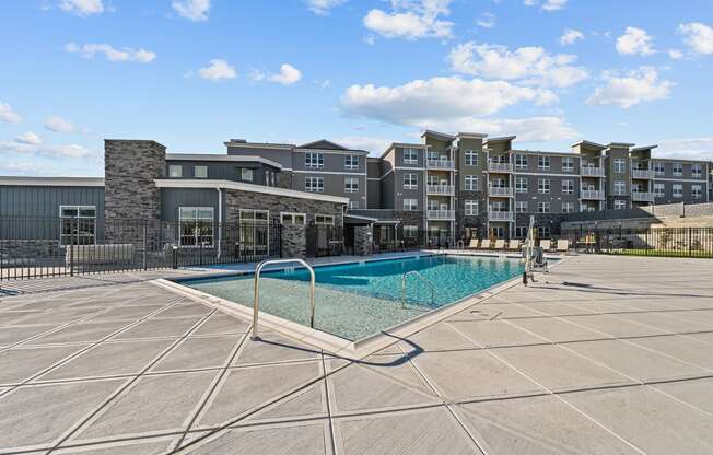 a swimming pool with an apartment building in the background