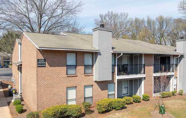 A brick building with a balcony on the second floor.