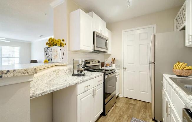 a kitchen with white cabinets and stainless steel appliances