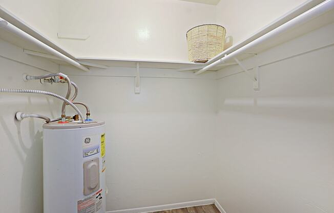 a laundry room with a washer and dryer and a shelf with a basket on top