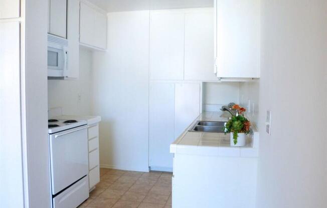 a kitchen with white cabinets and a white stove top oven