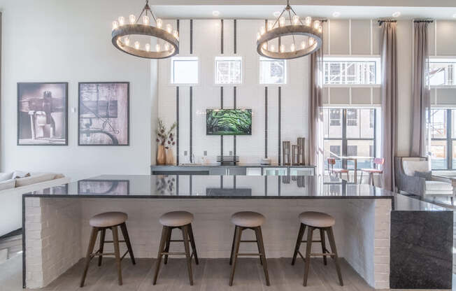 a large kitchen with three stools in front of a counter top
