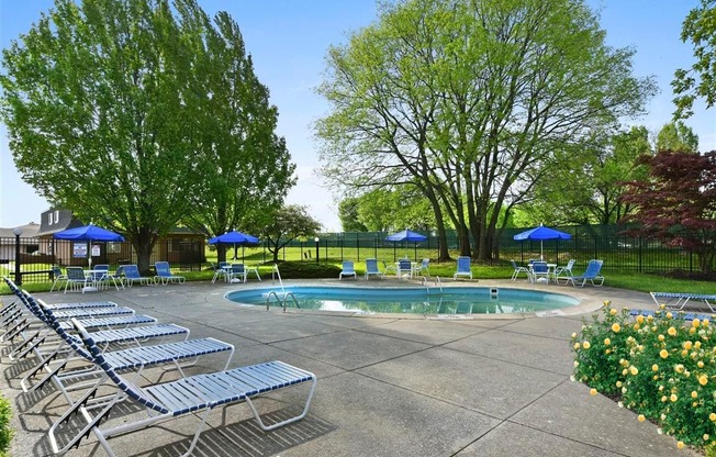 a pool with chairs and umbrellas next to it