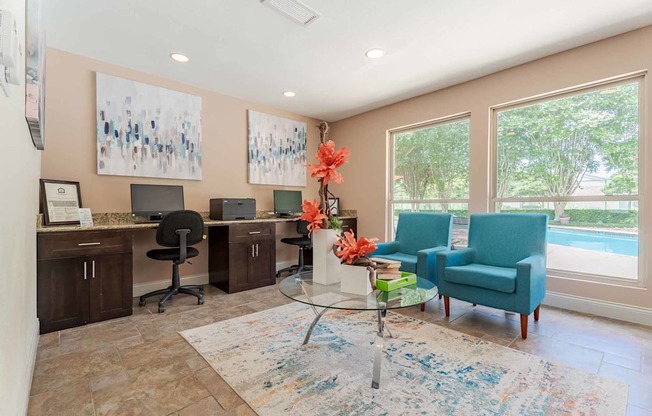 A room with a blue chair and a table with flowers on it.